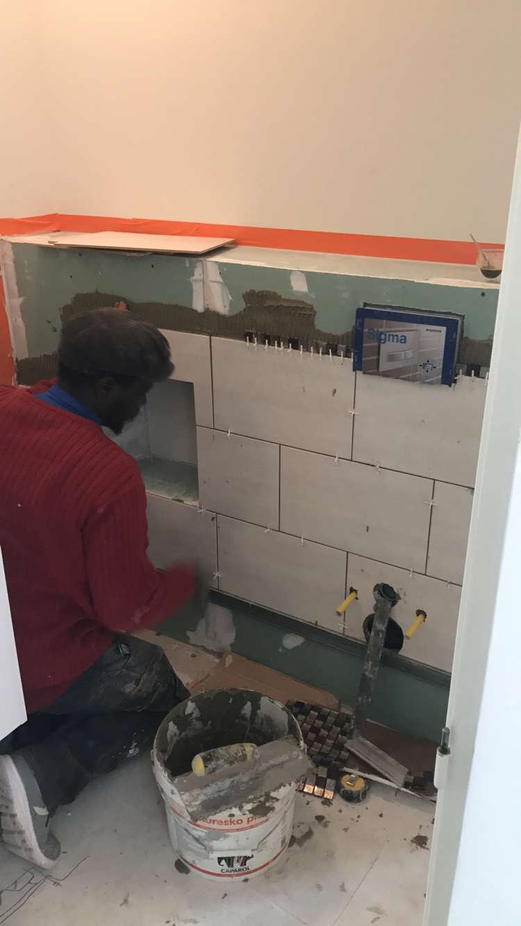 plombier en train de réparer un mur